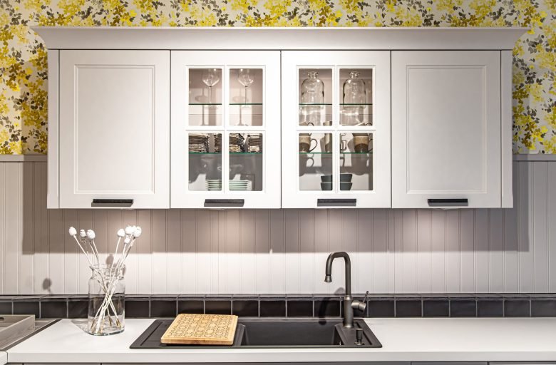 White kitchen cabinet with dishes, part of the kitchen interior.